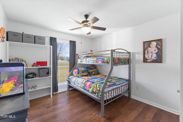 bedroom with a textured ceiling, wood finished floors, a ceiling fan, and baseboards