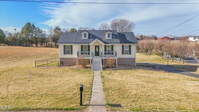 view of front of home with metal roof, covered porch, fence, stairway, and a front lawn