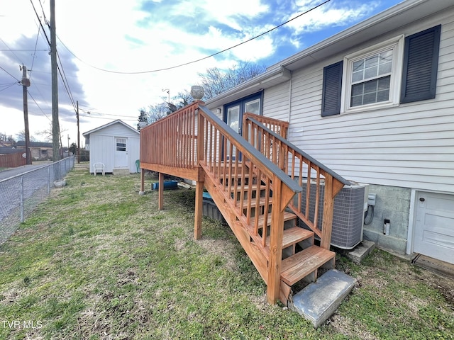 view of yard featuring central air condition unit, a storage unit, fence, an outdoor structure, and a wooden deck