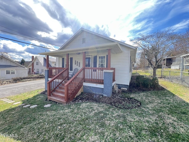 bungalow-style house with covered porch, a front lawn, and fence