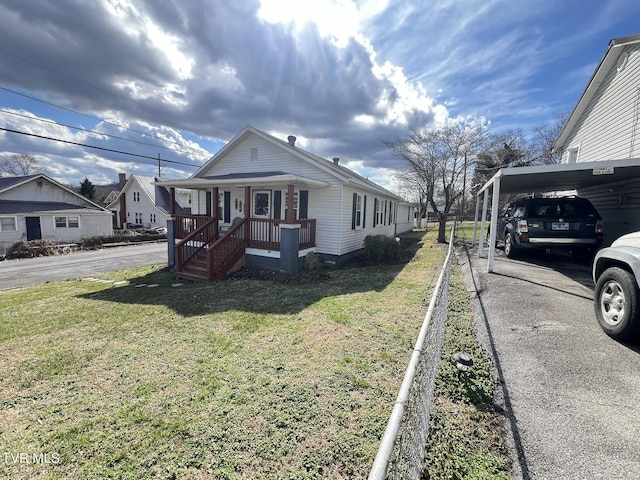 view of side of property with a carport, driveway, and a lawn