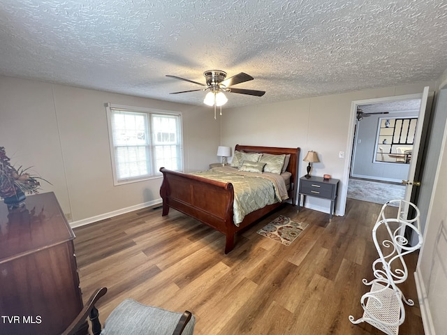 bedroom with ceiling fan, a textured ceiling, and wood finished floors