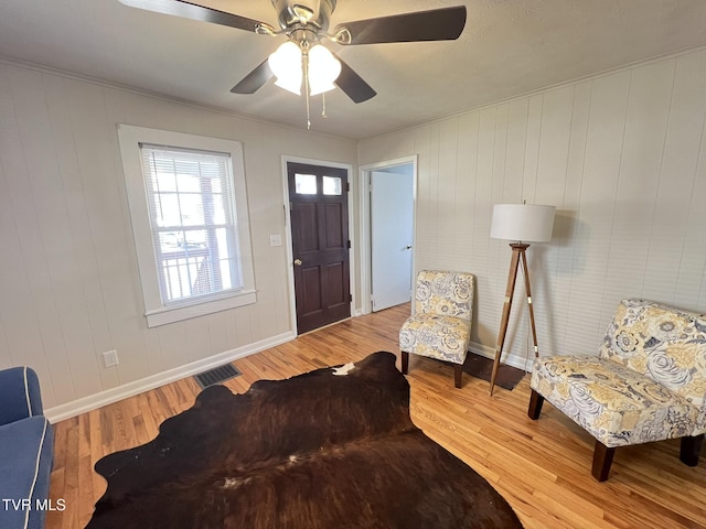 foyer featuring ornamental molding, wood finished floors, visible vents, and baseboards