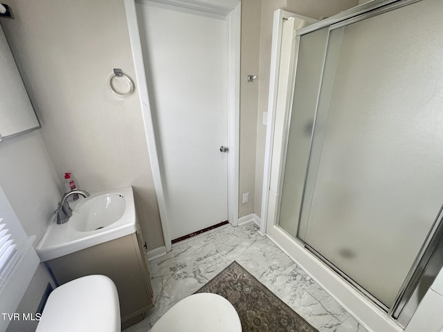 bathroom featuring marble finish floor, a stall shower, vanity, and toilet