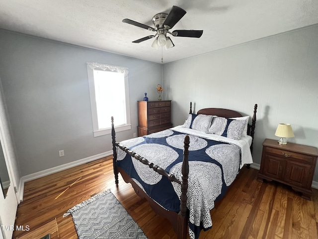 bedroom featuring a textured ceiling, wood finished floors, a ceiling fan, and baseboards