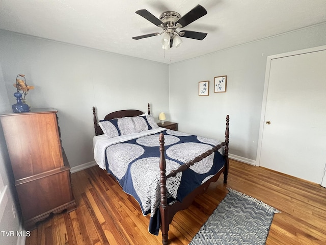 bedroom with ceiling fan, baseboards, and wood finished floors