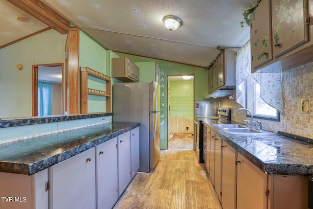 kitchen with appliances with stainless steel finishes, vaulted ceiling with beams, backsplash, and a sink