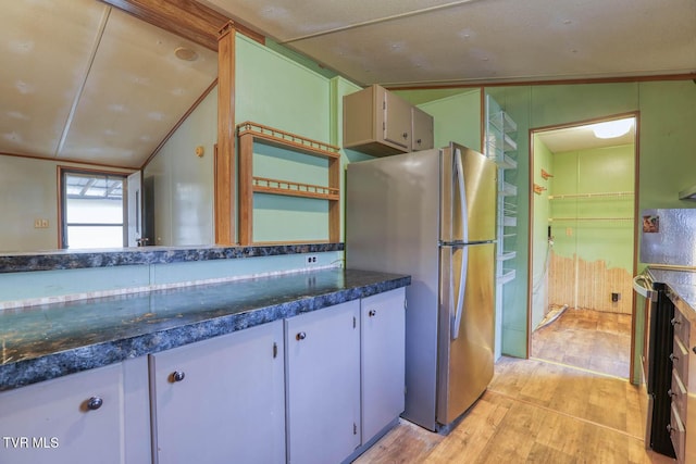 kitchen featuring white cabinets, vaulted ceiling, light wood-style floors, freestanding refrigerator, and dark countertops