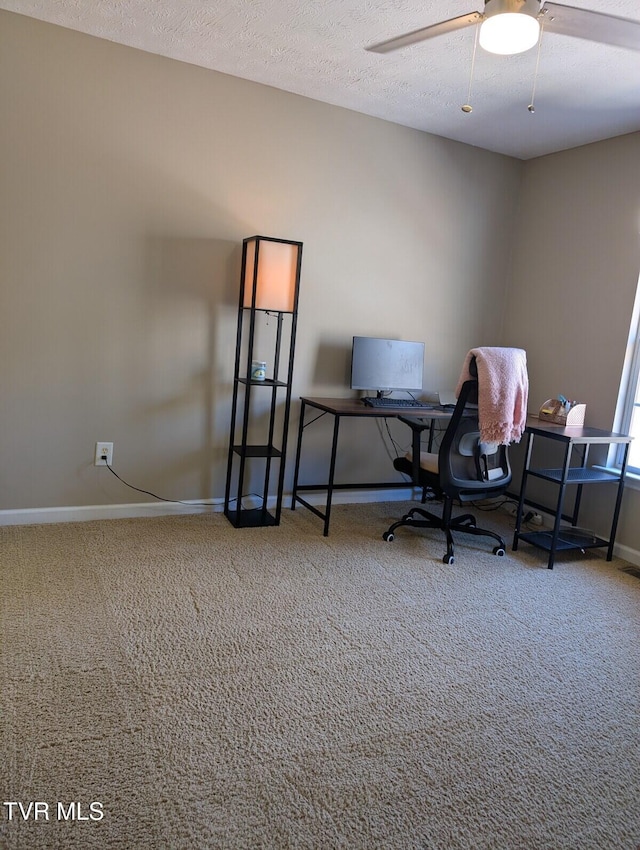 office space with a ceiling fan, carpet, baseboards, and a textured ceiling