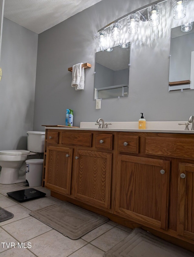 bathroom featuring toilet, vanity, and tile patterned floors