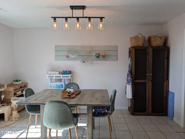 dining area with visible vents, light tile patterned flooring, a textured ceiling, and baseboards