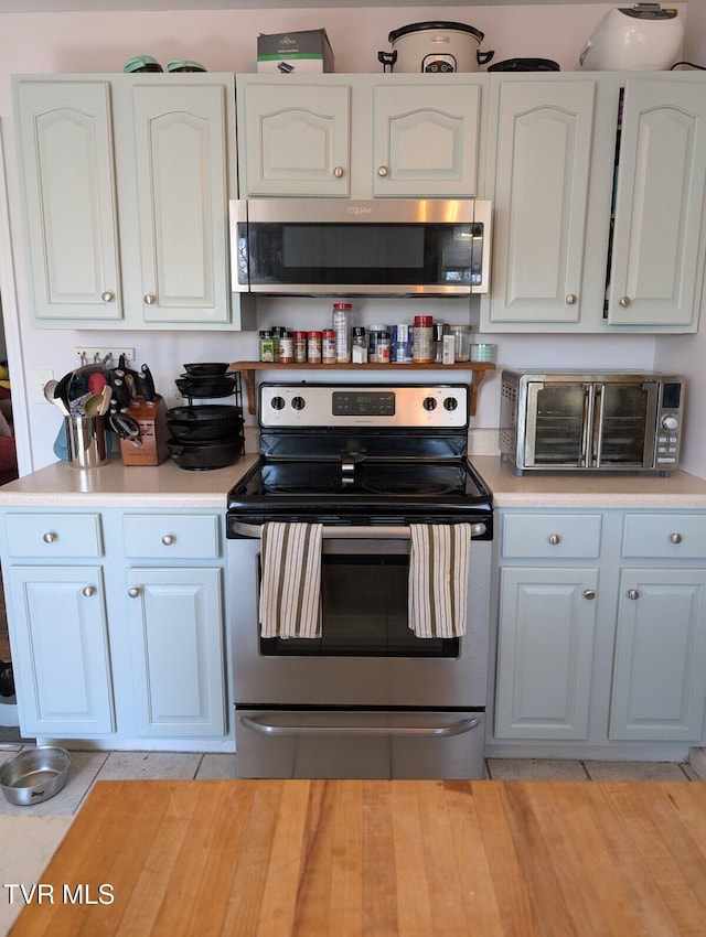 kitchen featuring white cabinetry, a toaster, appliances with stainless steel finishes, and light countertops