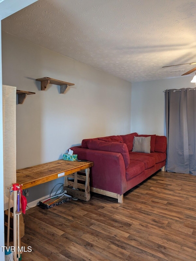 living area with a textured ceiling and wood finished floors