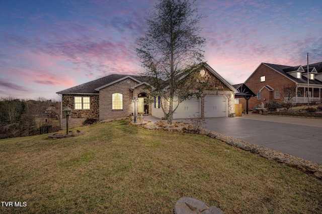 single story home featuring a garage, driveway, brick siding, and a lawn