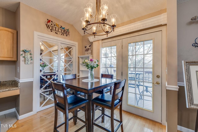 dining room with lofted ceiling, a textured ceiling, baseboards, french doors, and light wood finished floors