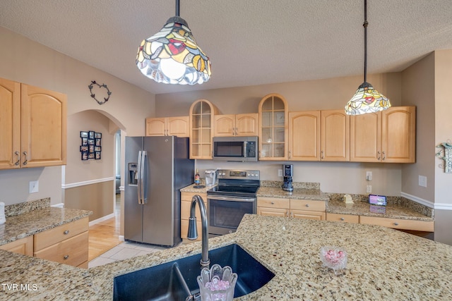 kitchen featuring light brown cabinets, stainless steel appliances, and a sink