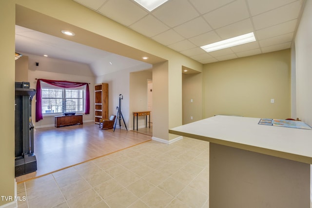 interior space featuring a paneled ceiling, light tile patterned flooring, baseboards, and recessed lighting