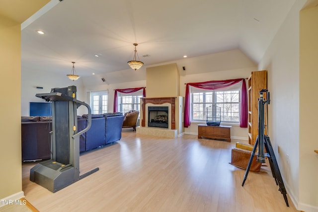 exercise area featuring a wealth of natural light, a high end fireplace, recessed lighting, and wood finished floors