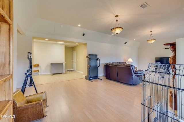 living room featuring visible vents, baseboards, lofted ceiling, light wood-style flooring, and recessed lighting