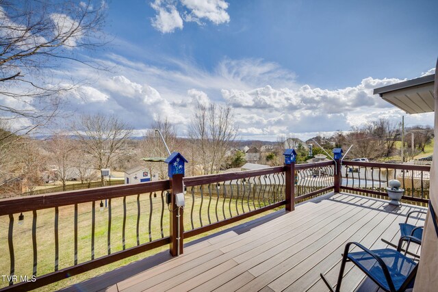 wooden terrace featuring a lawn