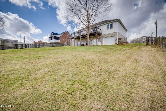 view of yard with a garage, a deck, and fence