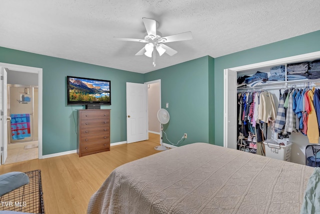 bedroom with ceiling fan, baseboards, wood finished floors, a closet, and a textured ceiling