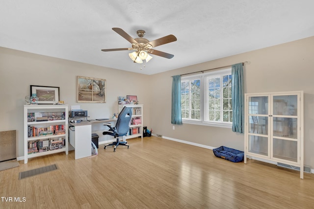 office featuring a ceiling fan, visible vents, wood finished floors, and baseboards