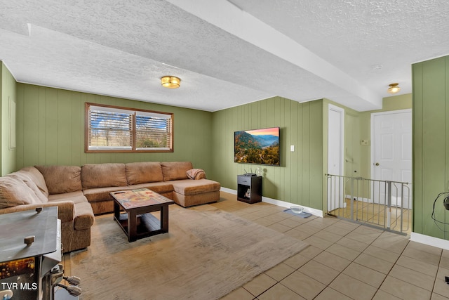 tiled living room featuring baseboards and a textured ceiling