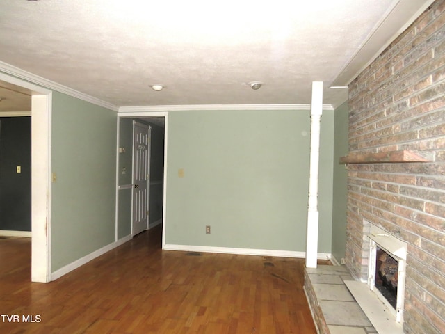 unfurnished living room with baseboards, a brick fireplace, wood finished floors, and crown molding