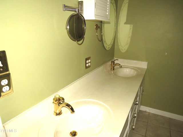 full bathroom with double vanity, tile patterned flooring, baseboards, and a sink