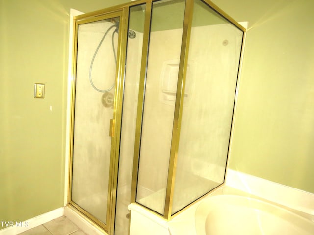 full bath featuring a garden tub, tile patterned flooring, and a shower stall