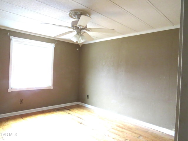 unfurnished room featuring ceiling fan, ornamental molding, wood finished floors, and baseboards