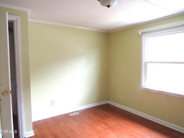 empty room featuring a healthy amount of sunlight, visible vents, baseboards, and light wood finished floors