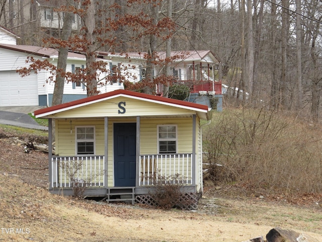 view of front of home featuring driveway, a porch, and an attached garage