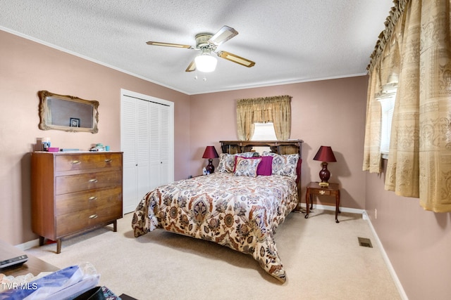 carpeted bedroom with a textured ceiling, ornamental molding, a closet, and visible vents