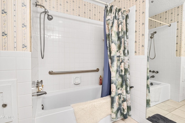 full bath featuring a textured ceiling, tile walls, tile patterned floors, shower / bath combo with shower curtain, and wallpapered walls