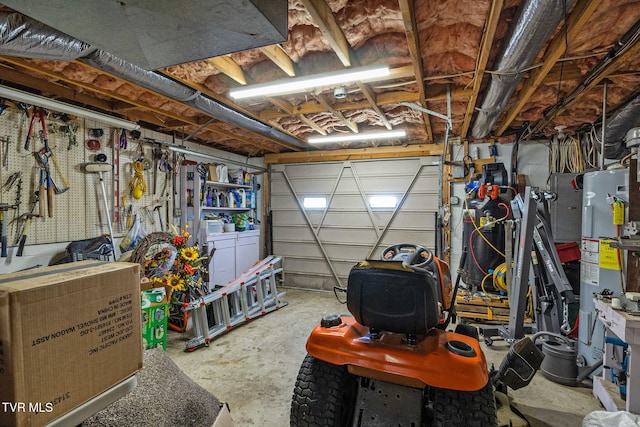 garage with water heater, a workshop area, and separate washer and dryer
