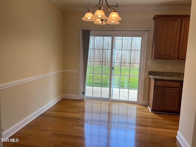 unfurnished dining area featuring ornamental molding, wood finished floors, and a wealth of natural light