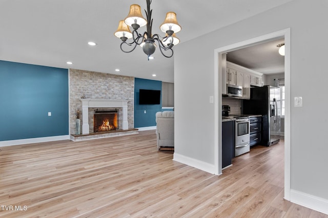 kitchen with baseboards, stainless steel appliances, light wood-style floors, white cabinetry, and tasteful backsplash