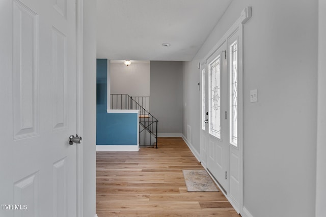 foyer entrance with light wood-type flooring and baseboards