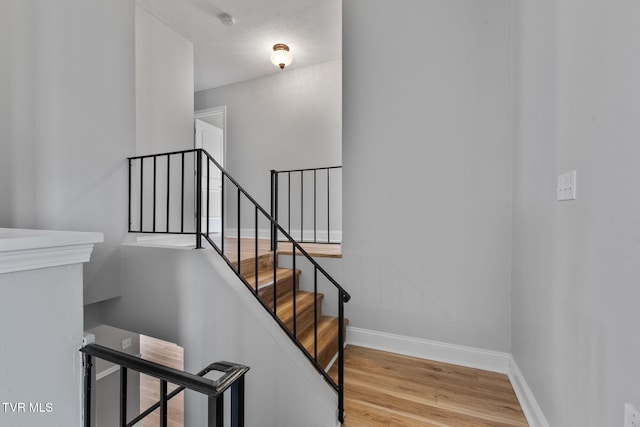 stairs featuring baseboards and wood finished floors