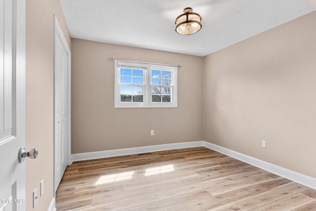 spare room with light wood finished floors and baseboards