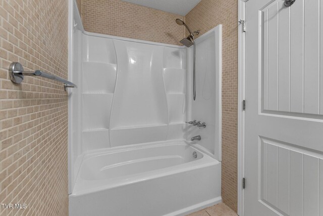 bathroom with tile patterned floors and  shower combination