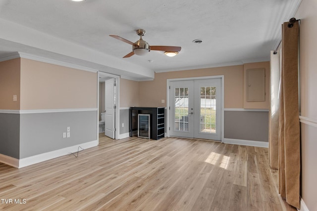 unfurnished living room featuring visible vents, baseboards, ornamental molding, french doors, and wood finished floors