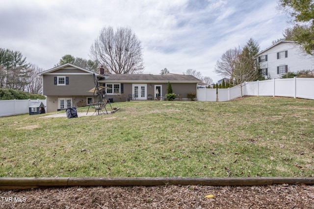 back of house featuring french doors, a lawn, and a fenced backyard