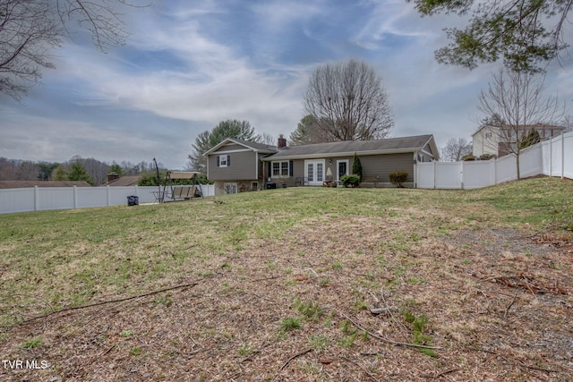 rear view of house with a gate, french doors, a lawn, and a fenced backyard