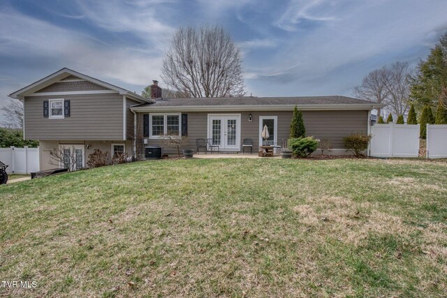 back of property featuring a patio, fence, a chimney, french doors, and a lawn