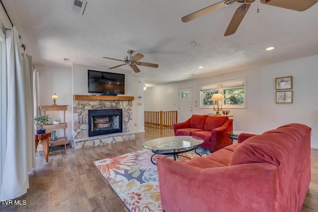 living room with visible vents, ceiling fan, wood finished floors, a fireplace, and recessed lighting