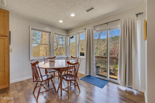 dining area with visible vents, baseboards, wood finished floors, a textured ceiling, and recessed lighting