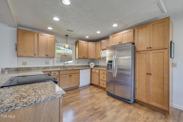 kitchen with light wood finished floors, white appliances, a sink, and visible vents